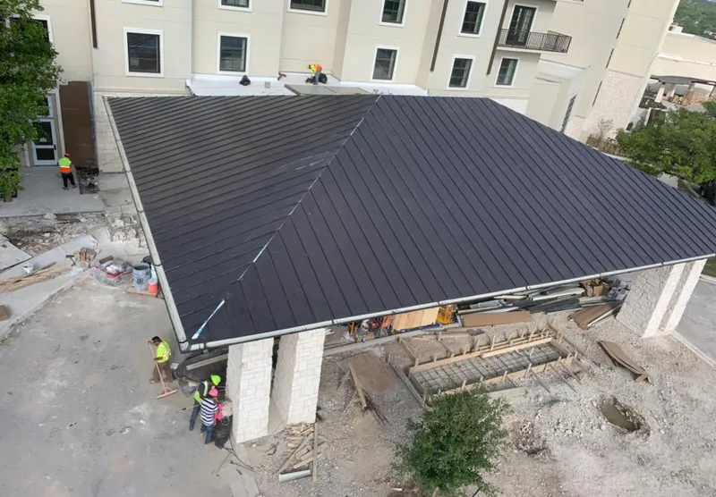 Metal roofing installation team working on a commercial building in Wooster